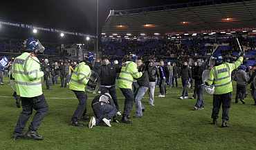 Birmingham City fans clash with the police on the pitch after team won their English League Cup soccer match against Aston Villa