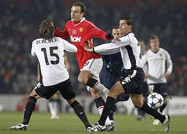 Valencia's Ricardo Costa and Angel Dealbert challenge Manchester United's Dimitar Berbatov during their Champions League Group C match in Manchester