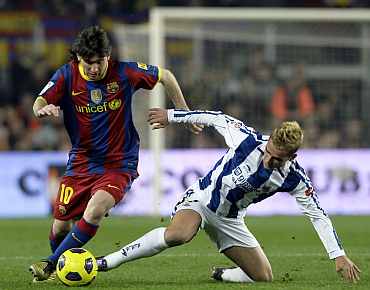Barcelona's Lionel Messi fights for the ball against Real Sociedad's Griezmann during their match at Nou Camp Stadium