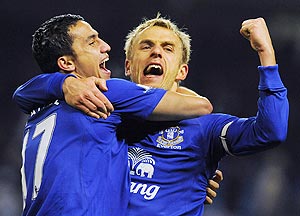 Everton's Tim Cahill (left) and Phil Neville celebrate after defeating Manchester City on Monday
