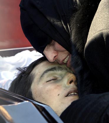 Dodo Kumaritashvili, the mother of Georgian luge competitor Nodar Kumaritashvili, embraces her son's body during a funeral in Bakuri