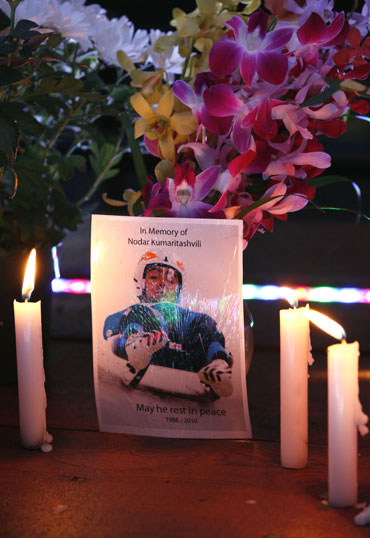 A postcard flanked by candles reads 'in memory of Nodar Kumaritashvili