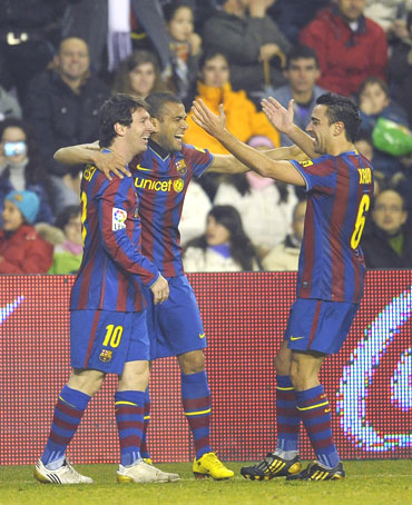 Barcelona's Daniel Alves with team-mates Lionel Messi and Xavi Hernandez