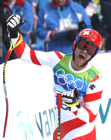 Switzerland's Didier Defago celebrates after crossing the finish line during the men's alpine skiing downhill event