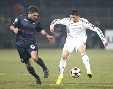 Real Madrid's Cristiano Ronaldo (right) challenges Olympique Lyon's Jeremy Toulalan