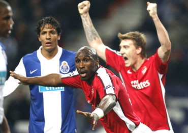 Arsenal's Sol Cambell (centre) and team-mate Nicklas Bendtner celebrate as Porto's Danii Alves (right) wears a dejected look