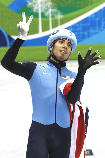 American speedskater and bronze medallist Apolo Anton Ohno holds up his fingers to indicate his seven Olympic medals