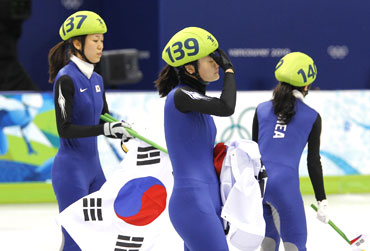 South Korea's Cho Ha-ri (left), Kim Min-jung (centre) and Lee Eun-byul react after their disqualification in the women's 3000 metres relay short track speed skating final