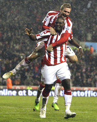 Stoke's Liam Lawrence hops onto Abdoulaye Faye in celebration after the latter scores against Fulham on Tuesday