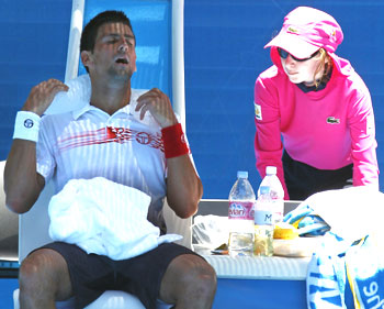 Novak Djokovic puts an ice pack around his neck as he takes a break during his match against Switzerland's Marco Chiudinelli