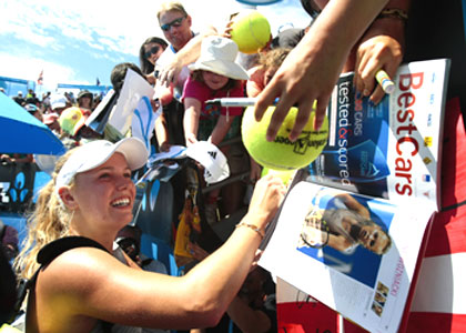 Denmark's Caroline Wozniacki signs autographs after defeating Julia Goerges of Germany