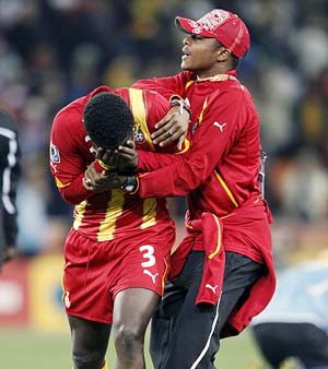 Asamoah Gyan is consoled by a team mate