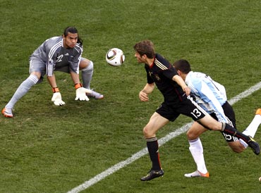 Germany's Thomas Mueller (centre) heads in the first goal past Argentina's goalkeeper Sergio Romero