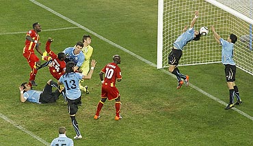 Suarez stops the ball with his hands on the goalline