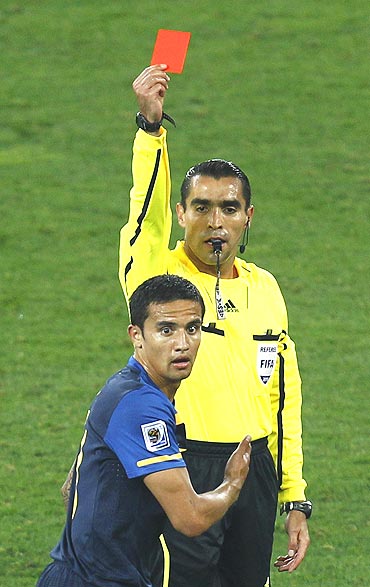Referee Marco Rodriguez flashes the red card to Australia's Tim Cahill after his tackle on Germany's Bastian Schweinsteiger