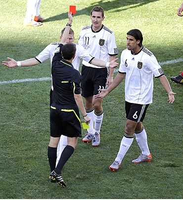 German players Bastian Schweinsteiger (left) and Sami Khedira (right) appeal to referee Alberto Undiano as he flashes the red card to Miroslav Klose (centre)