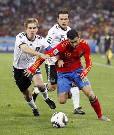 Pedro dribbles the ball past Philliph Lahm