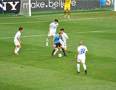 Diego Forlan dribbles past South Korean defenders