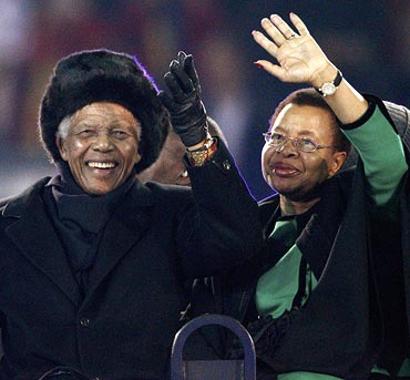 Mandela and his wife Graca Machel wave to the crowd at the Soccer City stadium in Johannesburg