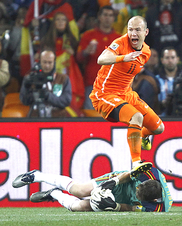 Netherlands' Arjen Robben looks back at referee Howard Webb as Spain's goalkeeper Iker Casillas dives to make a save