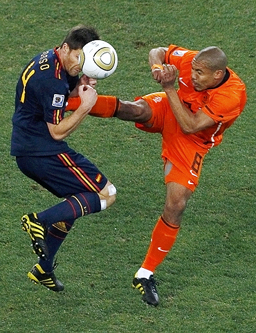 Spain's Xabi Alonso gets a boot in his chest as he is challenged by Dutch Nigel de Jong