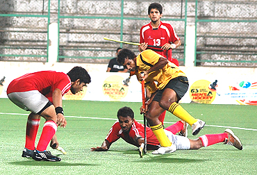 A player from Tamil is challenged by Delhi players