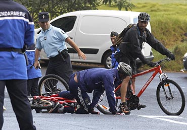 France's Nicolas Anelka falls as he cycles at le Tampon near Saint Pierre on the French overseas territory of La Reunion