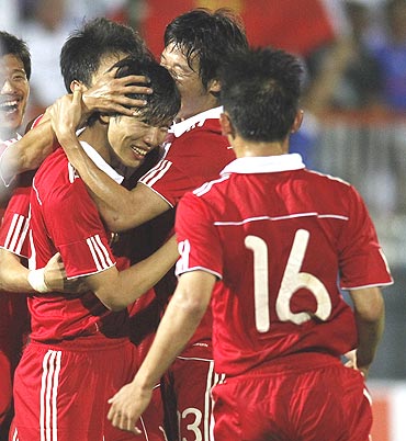 China's Deng Zhuoxiang (centre) celebrates with team-mates after scoring against France during their friendly tie at Michel Volnay stadium