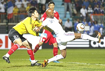 France's Nicolas Anelka (right) is challenged by China's goalkeeper Zeng Cheng (left) during their friendly tie