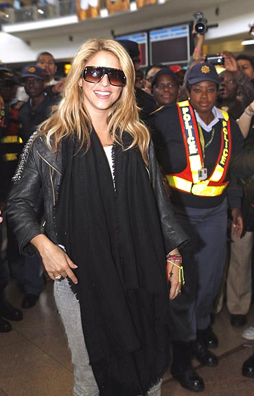 Colombian singer Shakira is escorted by police as she arrives at the Oliver Tambo International Airport in Johannesburg on Monday