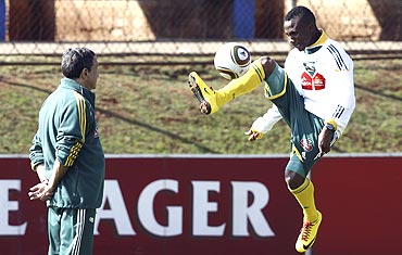 South Africa's Teko Modise controls the ball during a training session as coach Carlos Alberto Parreira (left) looks on