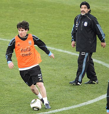Argentina's Lionel Messi trains as Maradona looks on