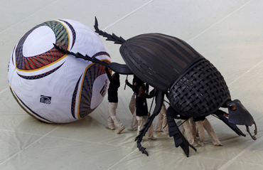 Performers carry replica of dung beetle during opening ceremony of the 2010 World Cup at Soccer City stadium