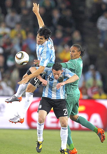 Nigeria's Chidi Odiah (right) battles for the ball with Argentina's Maxi Rodriguez (centre) and Nicolas Burdisso