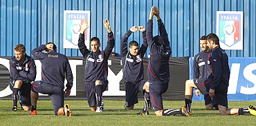 Italian players stretch during a training session