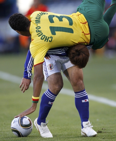Japan's Yuichi Komano is challenged by Cameroon's Eric Choupo-Moting