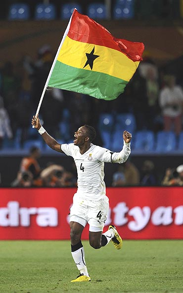Ghana's John Pantsil celebrates with his national flag after beating Serbia