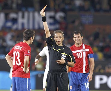 Serbia's Aleksandar Lukovic receives a red card from referee Hector Baldassi of Argentina
