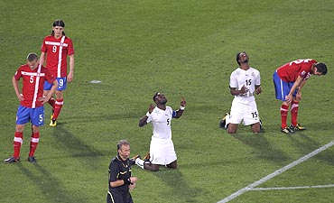 Ghana's John Mensah and Isaac Vorsah thank the Almighty after defeating Serbia