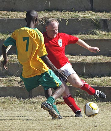 England's soccer fan Steve Harrison (right) vies for possession with inmate Moses Messo