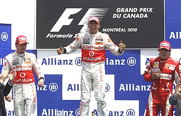 McLaren's Lewis Hamilton (centre) alongside second-placed team-mate, Jenson Button (2nd from left) and third-placed Fernando Alonso of Ferrari on the podium