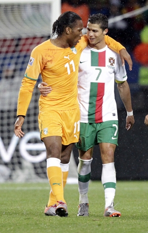 Ivory Coast's Didier Drogba walks with Portugal's Cristiano Ronaldo