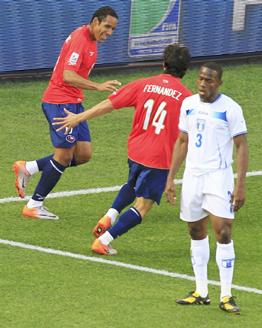 Chile's Jean Beausejour celebrates his goal with team mate Matias Fernandez during their 2010 World Cup Group H match against Honduras