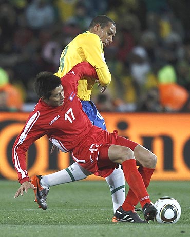 North Korea's An Yong-hak (left) vies for the ball with Brazil's Gilberto Silva