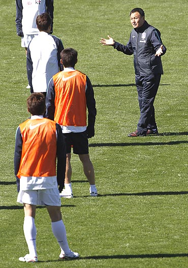 South Korea's coach Huh Jung-moo (right) instructs players during a training session