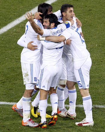 Greece's Giorgos Karagounis celebrates with his teammates after their win