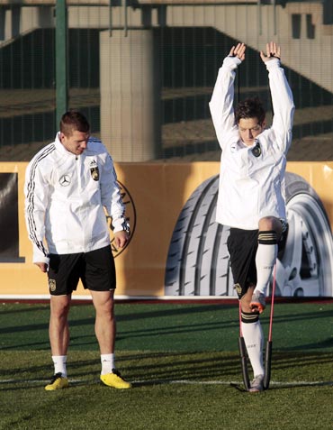 Germany's Mesut Oezil and Lukas Podolski (left) take part in a training session