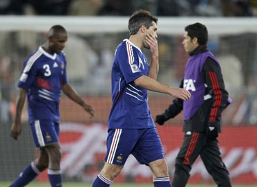 France's Jeremy Toulalan and Eric Abidal walk off dejected after their loss to Mexico