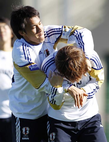 Japan's Okazaki jokes with a team-mate during a training session for the World Cup