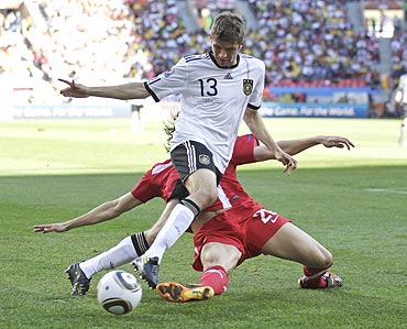 Germany's Thomas Mueller (13) and Serbia's Neven Subotic vie for possession